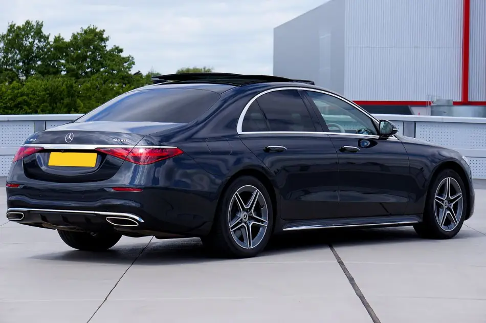 A dark Mercedes-Benz S-Class executive saloon parked outside a corporate building